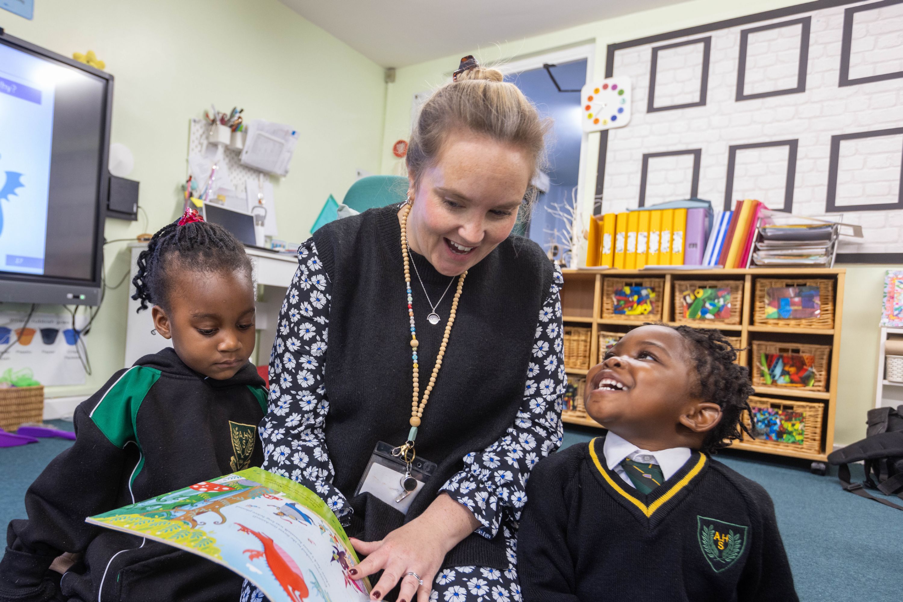Children reading with their teacher