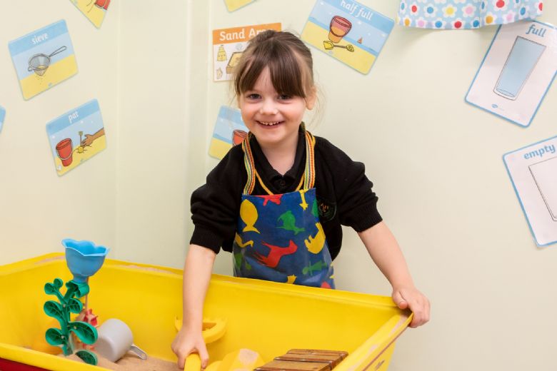 Young girl playing in sandpit